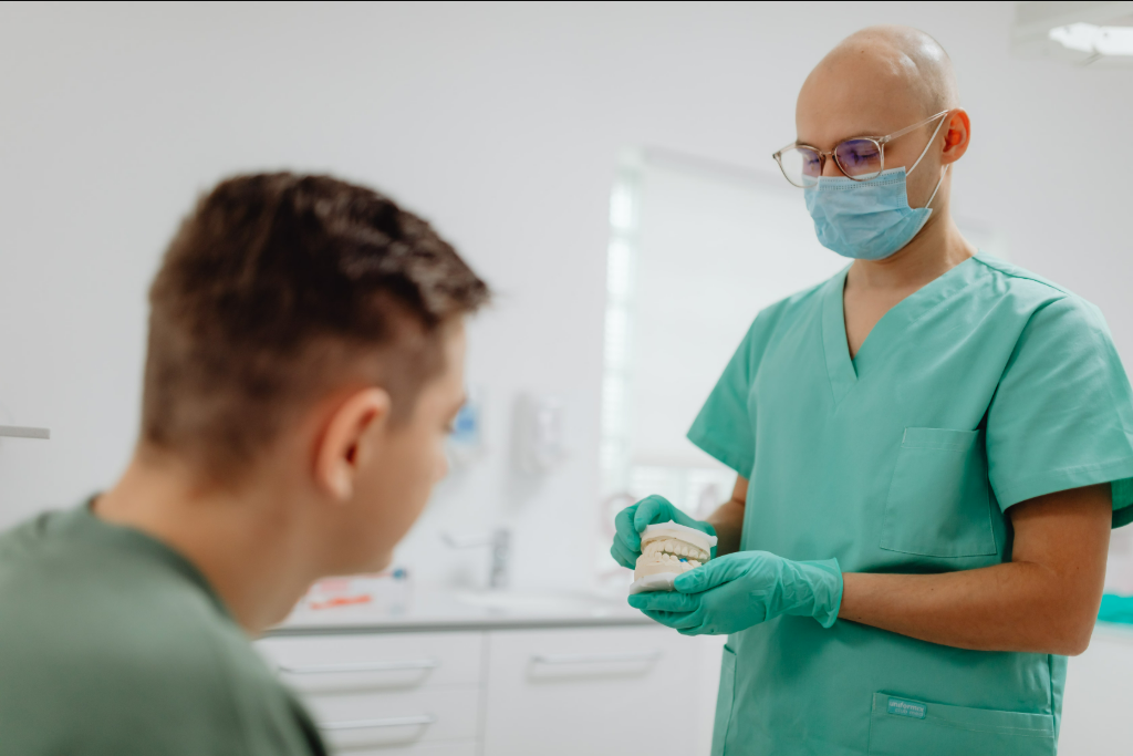 Dentista a explicar uma reabilitação oral a um paciente numa consulta